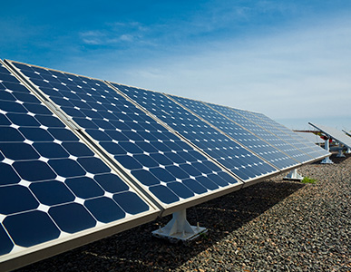 Panele fotowoltaiczne ułożone w bloki na ziemi.